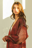 Shimmering red metallic knit V-neck cardigan with loose fit and textured open front.