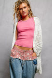 White openwork cardigan with scalloped edge, lightweight knit, loose fit, worn over pink top.